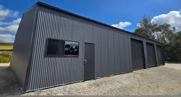 NBT Construction shed builder homepage image of a large commercial shed in black.